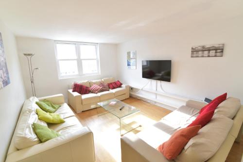 a living room with two couches and a tv at Beach Central with Allocated Parking and Patio in Brighton & Hove