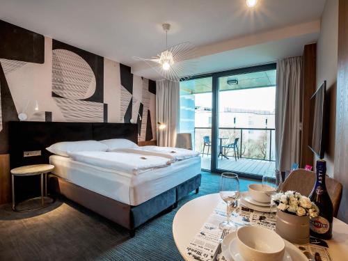 ein Hotelzimmer mit einem Bett und einem Tisch in der Unterkunft VacationClub – Seaside Apartament 348 in Kołobrzeg