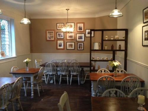 a dining room with tables and chairs and pictures on the wall at Castle Hotel in Eynsford