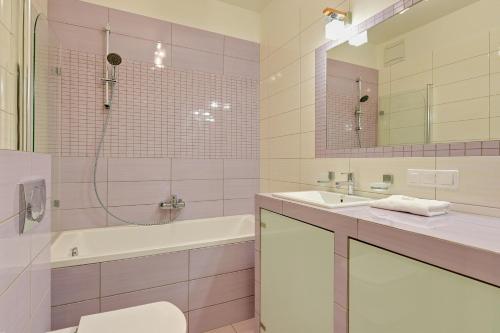 a bathroom with a sink and a tub and a toilet at Downtown Apartments Hallera 165 in Gdańsk