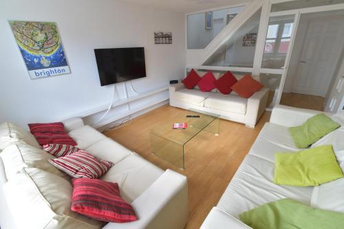 a living room with two white couches and a television at Beach Central with Allocated Parking and Patio in Brighton & Hove