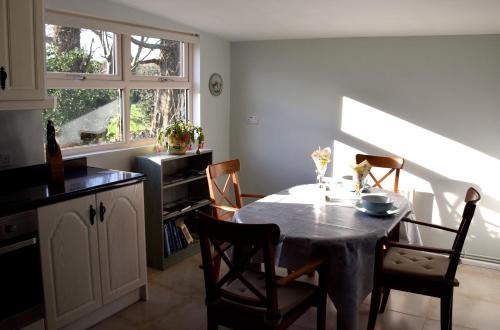 a kitchen with a table and chairs and a window at Tuck Mill Cottage in Castlewellan