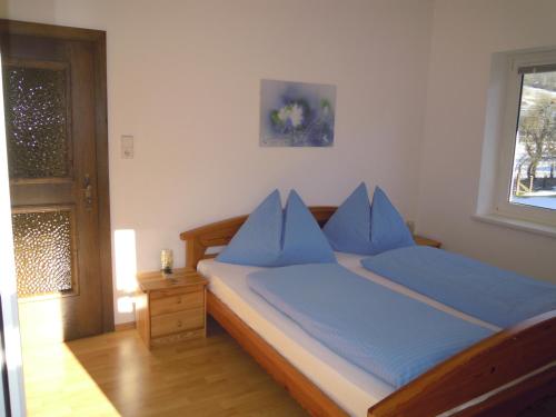 a bedroom with a bed with blue pillows on it at Ferienwohnungen Familie Jarnig Inge in Görtschach