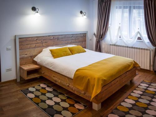 Un dormitorio con una cama grande con cabecero de madera. en Vila Molidul Zarnesti, en Zărneşti