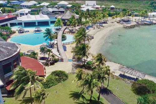 an aerial view of a resort with a pool and a beach at MANGANAO LOFTS INN Bord de Mer in Saint-François