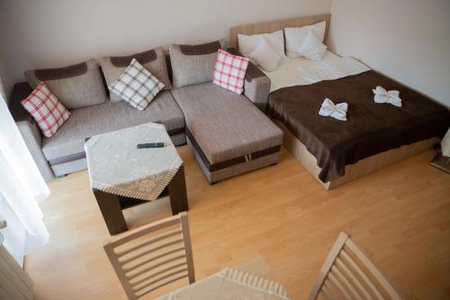 a living room with a bed and a couch at Willa i domki Victoria in Wisła