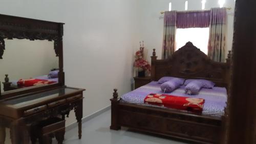 a bedroom with a wooden bed and a mirror at DARRA HOMESTAY TORAJA in Rantepao