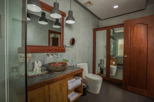 a bathroom with a sink and a toilet and a mirror at Cambana Residence in Siem Reap