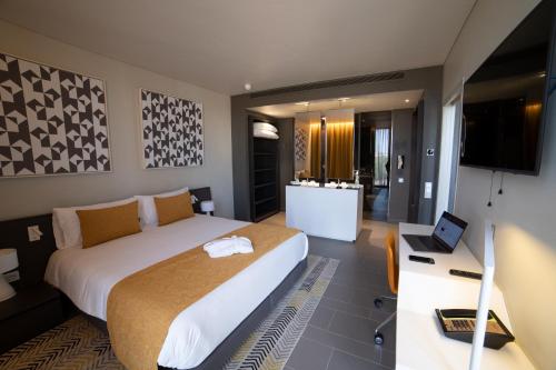 sypialnia z łóżkiem i biurkiem z laptopem w obiekcie Noom Hotel Niamey w mieście Niamey