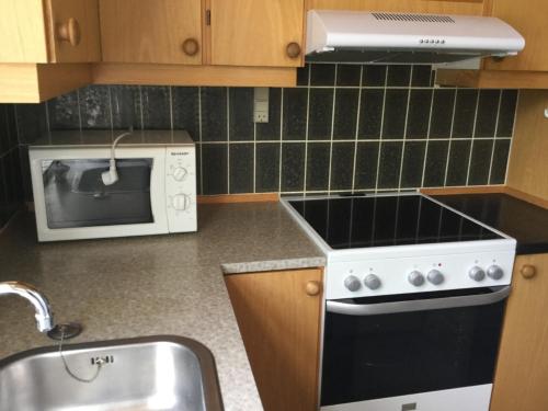 a kitchen with a stove and a microwave at Ørstedsgade, Sønderborg in Sønderborg