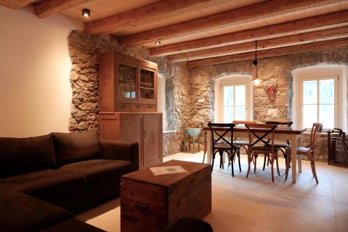 een woonkamer met een bank en een tafel met stoelen bij Appartamenti La Rocia in Rocca Pietore