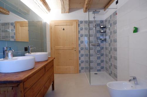a bathroom with two sinks and a shower at Appartamenti La Rocia in Rocca Pietore
