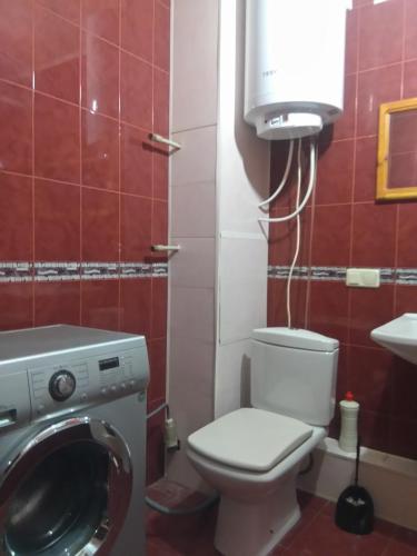 a bathroom with a toilet and a washing machine at Просторная 1комнатня квартира напротив ТРЦ Дафи Ашан рядом ресторан Альтбир in Kharkiv