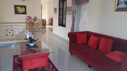 a living room with a red couch and a table at DARRA HOMESTAY TORAJA in Rantepao