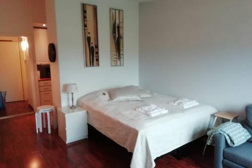 - une chambre avec un lit blanc et un canapé bleu dans l'établissement Nice apartment in Vaasa, à Vaasa