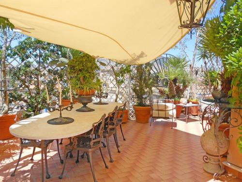 un patio con tavoli, sedie e piante in vaso di Apartment Giardino delle Palme by Interhome a Palermo