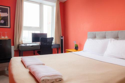 a bedroom with a bed with red walls and a desk at Bray Guest Rooms in London