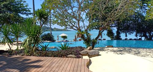 a resort swimming pool with a view of the water at SYLVAN Koh Chang in Ko Chang