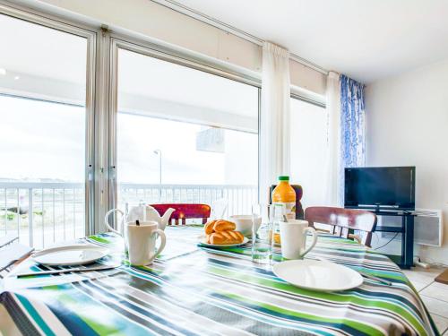 een eetkamer met een tafel en een groot raam bij Apartment Port Maria-1 by Interhome in Quiberon