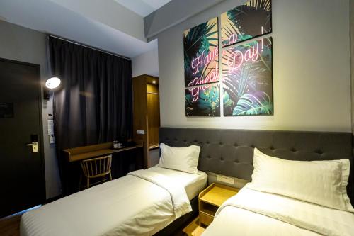 a hotel room with two beds and a desk at Brown Hotel in George Town