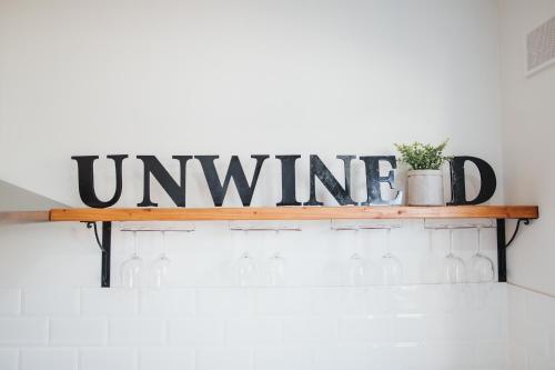 a wooden sign on a shelf with wine bottles at White on Wright Clare in Clare
