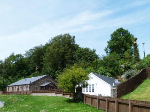 a house in a field with a fence at Holiday Home Cwm Tawel by Interhome in Pentyrch