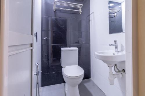a bathroom with a white toilet and a sink at Hentian Hotel Kajang in Kajang