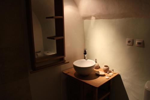 une salle de bain avec un lavabo et un miroir sur un comptoir dans l'établissement Ancienne Abbaye de Franquevaux Lou Pitchoun, à Franquevaux