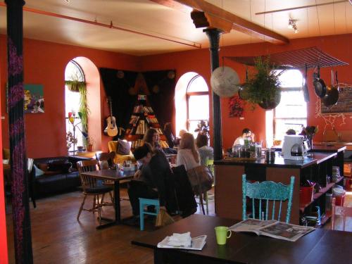 a group of people sitting at tables in a restaurant at Auberge Alternative in Montréal