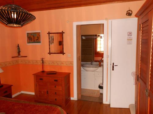a bedroom with a bathroom with a sink and a mirror at Chambres d'hôtes Al Camp d'Espalougues in Ur