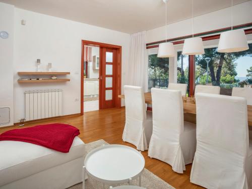 ein Wohnzimmer mit einem weißen Sofa und einem Tisch in der Unterkunft Holiday Home Villa Beach Front by Interhome in Savudrija
