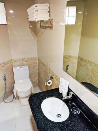 a bathroom with a sink and a toilet and a mirror at 456 Hotel in Baguio