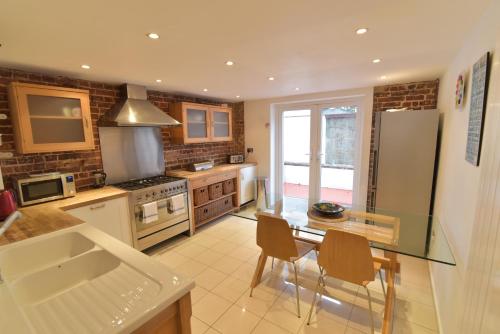a kitchen with a table and a refrigerator at Beach Central with Allocated Parking and Patio in Brighton & Hove