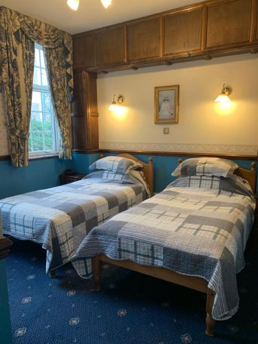 Duas camas num quarto com paredes azuis em Lyndon House em Walsall