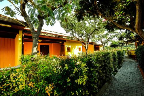 an orange house with a hedge in front of it at Residence New Paradise in Tropea