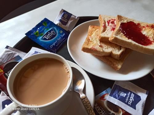 a cup of coffee and a plate of toast at TGF Dream Guest House in Majorda