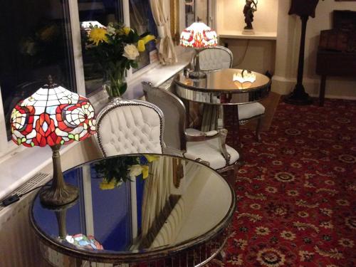 a room with a table and chairs with flowers on it at Palmerston Grange in Shanklin