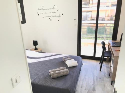a bedroom with a bed with two towels on it at Appartement 3 pieces, refait a neuf, haut standing, piscine, mer a pieds in Antibes