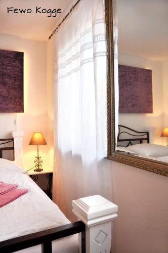a bedroom with two beds and a mirror at Ferienhaus - Am Kütertor - alle Apartments mit Terrasse oder Balkon - in top Lage in Stralsund