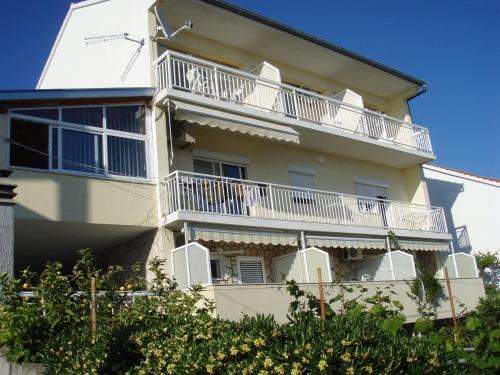 un edificio blanco con balcones en un lateral en Guesthouse Iva, en Hvar