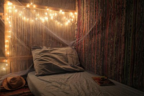 Cette chambre dispose d'un lit avec des lumières sur le mur. dans l'établissement Falak, à Taba