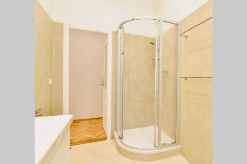 a bathroom with a shower with a glass door at Beautiful Viennese Flat In The City Centre in Vienna
