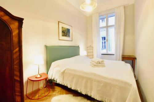 a bedroom with a white bed and a window at Beautiful Viennese Flat In The City Centre in Vienna