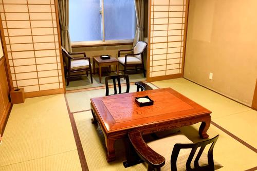 a room with a table and chairs in a room at Tabist Kappo-Ryokan Ooriya Kochi in Sagamichō
