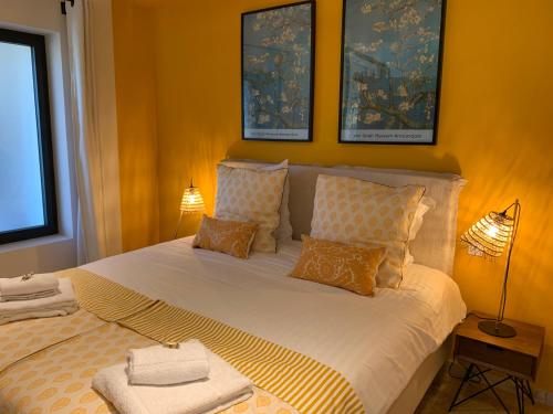 a bedroom with a large white bed with two lamps at Mas Notre Dame in Eygalières