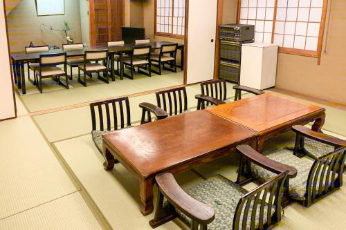 a dining room with a wooden table and chairs at Tabist Kappo-Ryokan Ooriya Kochi in Sagamichō