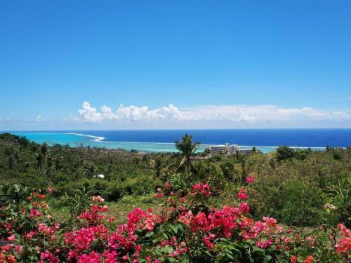 uma vista para o oceano a partir de uma colina com flores em Saipan Skyline Designers Hotel em Saipan