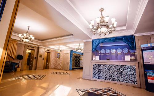 a lobby with a blue wall and a chandelier at Grand Sapphire Hotel in Almaty