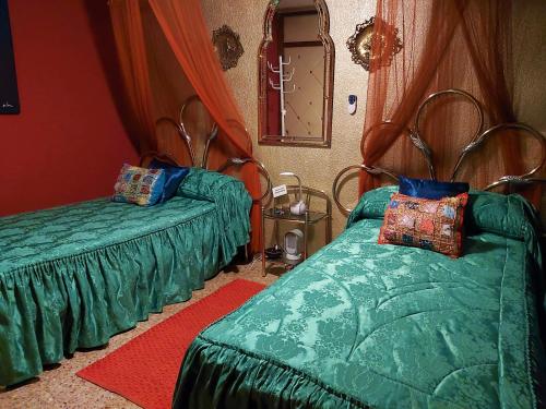 1 dormitorio con 2 camas verdes y espejo en Alicante Room and gayfriendly en Alicante