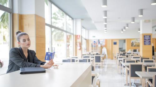 a woman sitting at a table in a cafeteria at Holiday Inn Express Valencia Bonaire by IHG in Aldaya